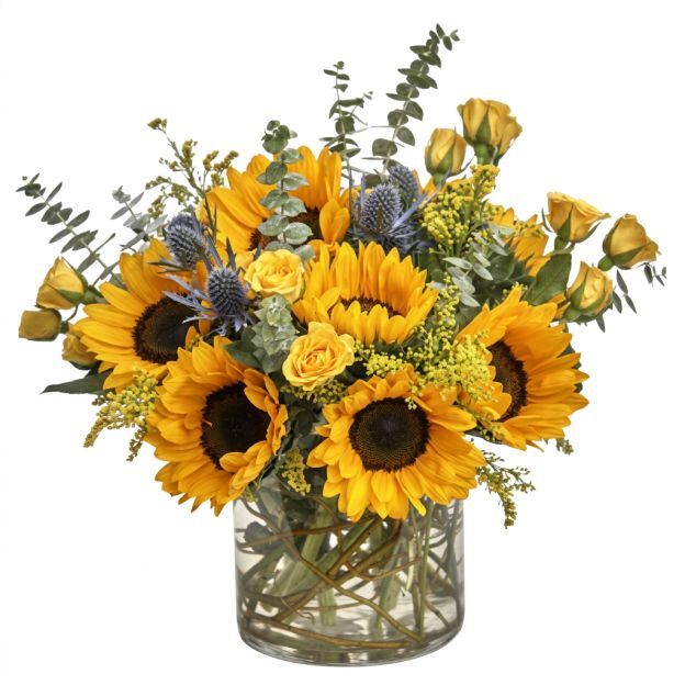 Bright floral arrangement featuring sunflowers, roses, and greenery in a clear glass vase.