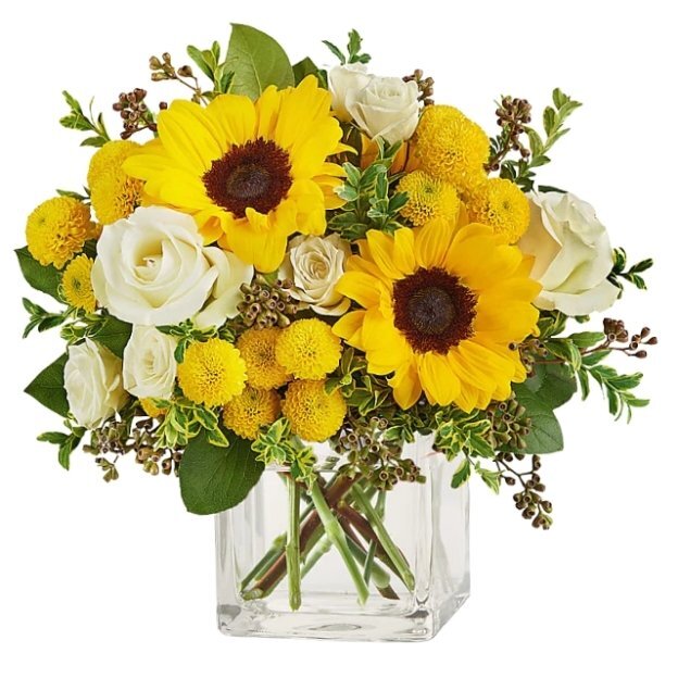 Glass cube vase bouquet with sunflowers, white roses, yellow pom pom flowers, and mixed greenery.
