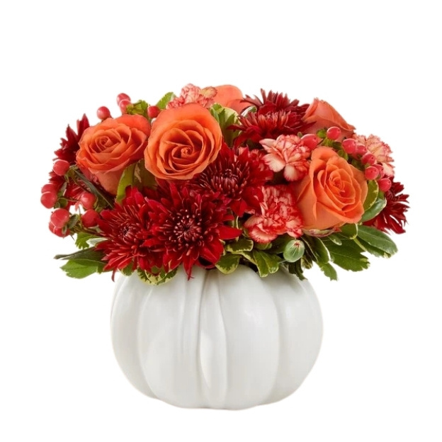 Orange roses, deep red chrysanthemums, pink carnations, and red berries arranged in a white pumpkin-shaped vase.